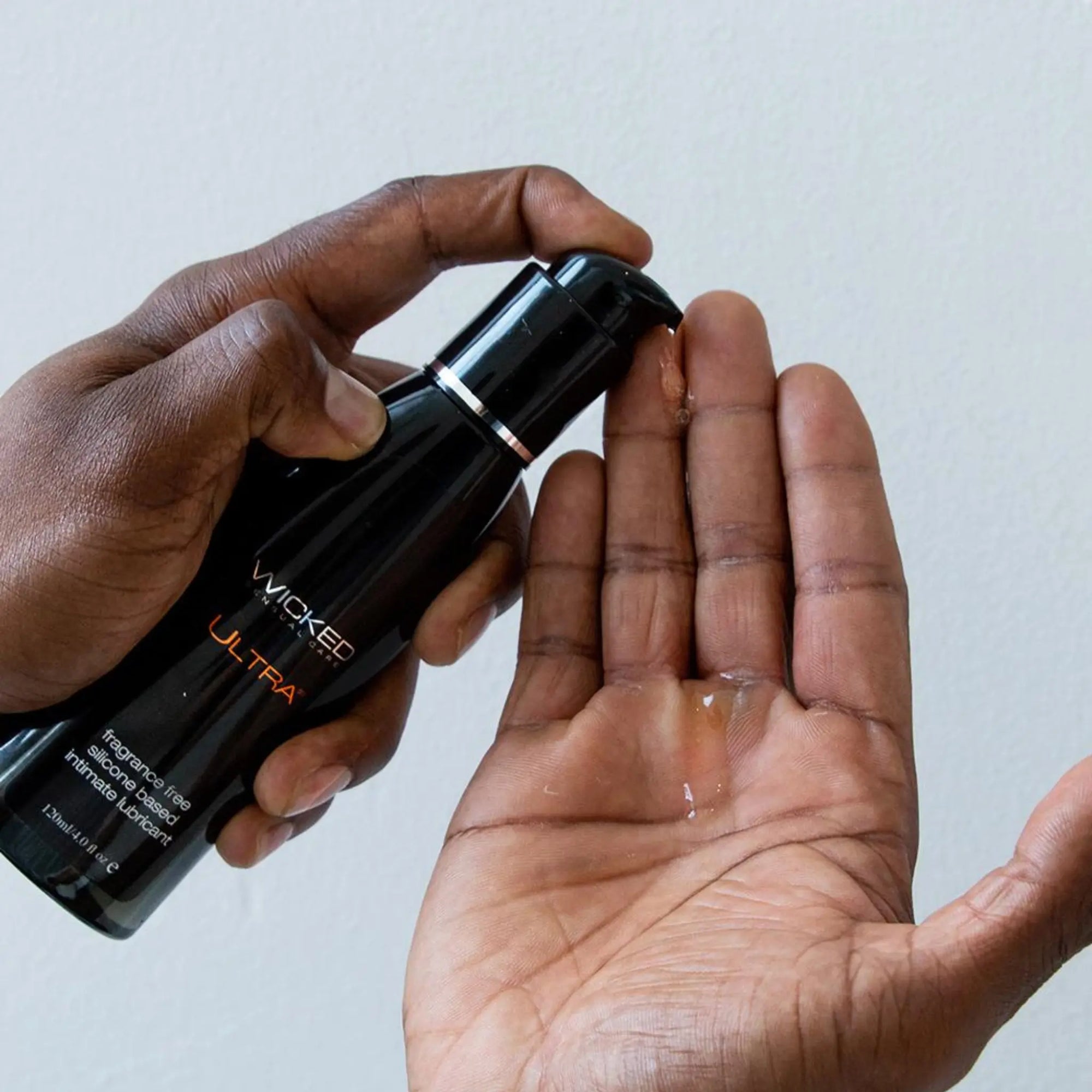 En hand sprutar ut Wicked Ultra Silikonbaserat Gildmedel 120ml på sin andra hand