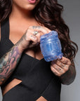 En kvinna håller i och visar upp en Fleshlight Quickshot Turbo Blue