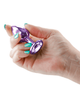 Hand som håller i Rear Assets Buttplug Small Purple mot vit bakgrund.