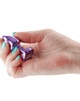 Hand som håller i Rear Assets Petite Purple buttplug mot vit bakgrund.