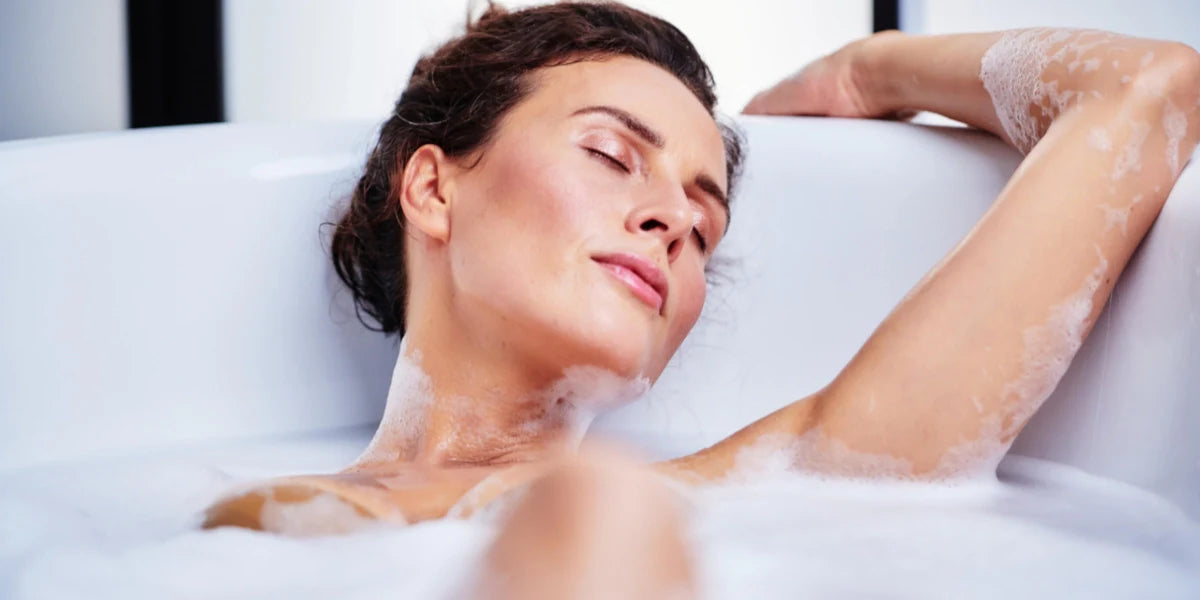 Kvinna ligger och slappnar av i ett bubbelbad