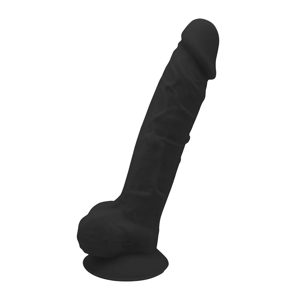 Real Love Dildo 17.7 cm Black ståendes mot vit bakgrund.