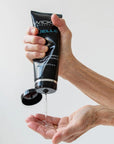 En hand häller Wicked Jelle Anal Vattenbaserat Glidmedel 240ml i sin andra hand