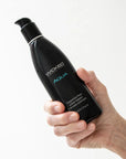En hand håller i en flaska med Wicked Aqua Vattenbaserat Glidmedel 250ml