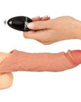 En hand håller i fjärkontrollen till Realistixxx Vibrerande Realistisk Penis Sleeve