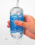 En hand håller i en Tenga Spinner DX Drops Masturbator