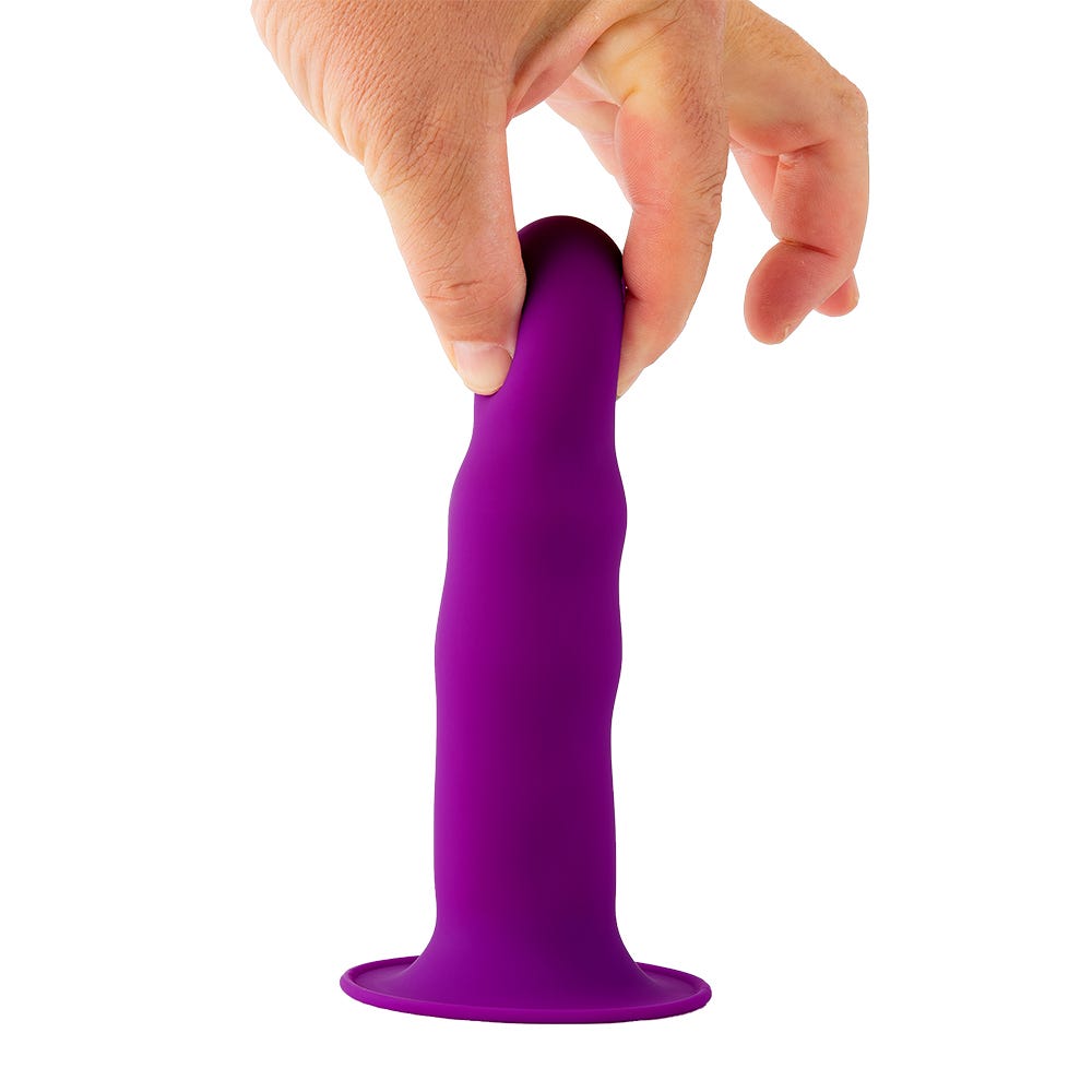 Hand som håller i Solid Love Ribbed Dildo mot vit bakgrund.