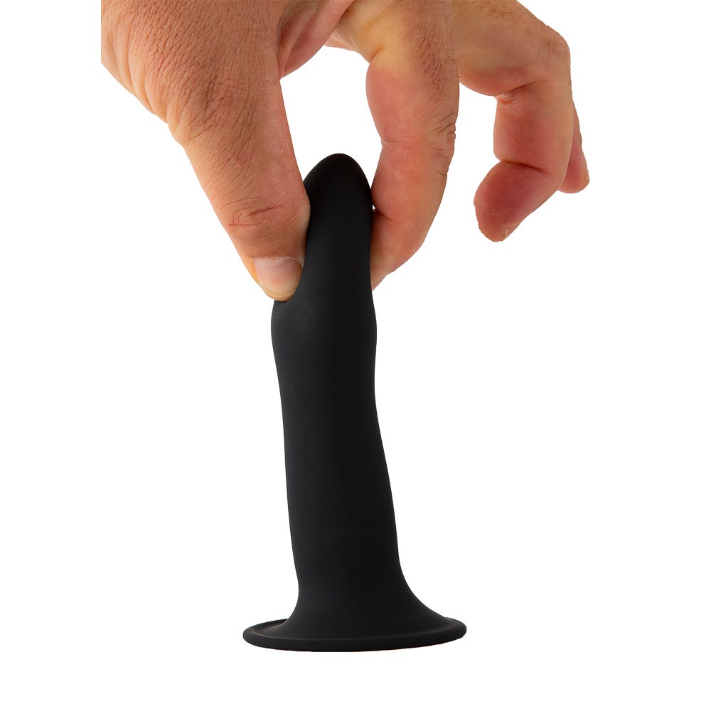 Hand som håller i Solid Love Dildo Black mot vit bakgrund.