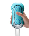 En hand håller i en Tenga Flip Orb Masturbator Blue