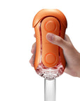 En hand demostrerar hur man använder Tenga Flip Orb Masturbator Orange