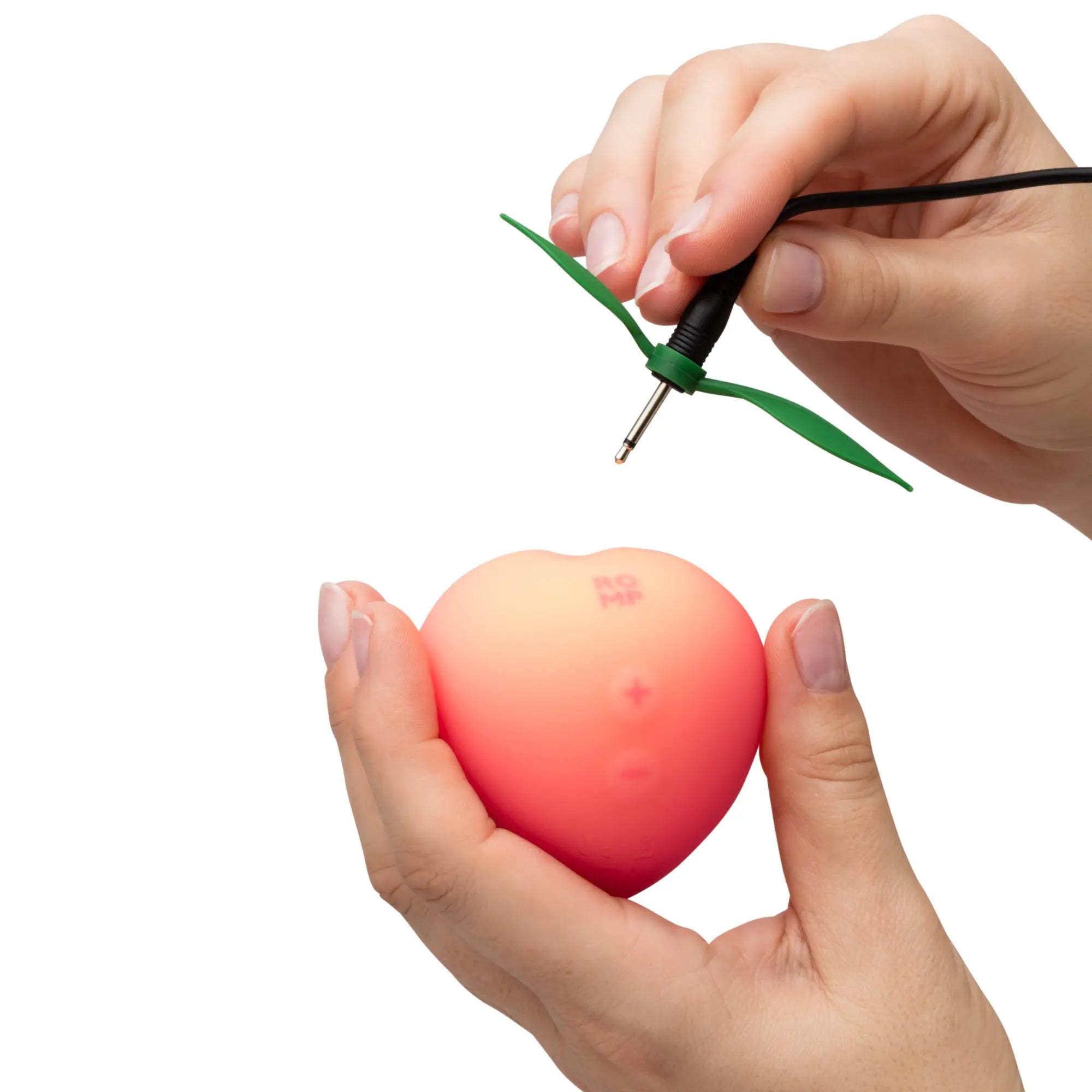 En kvinna visar hur du laddar Romp Peach Clitoral Stimulator