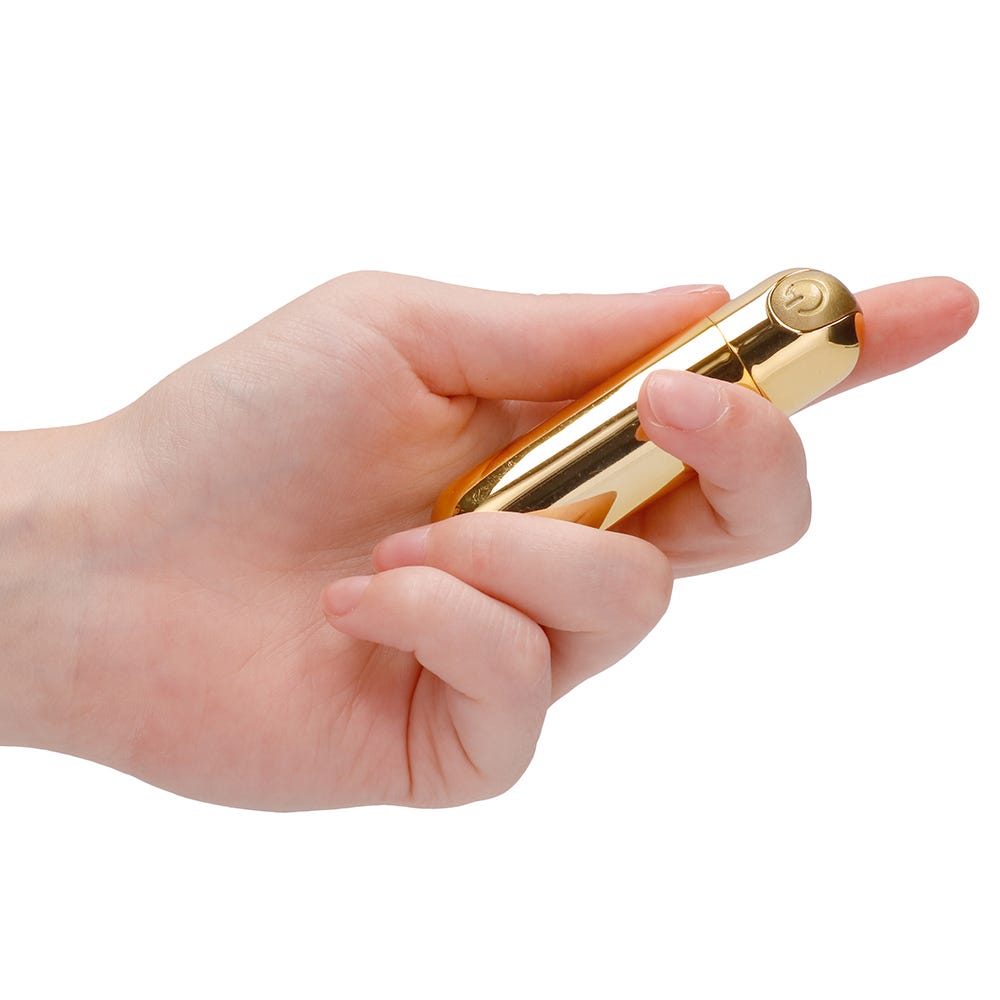 Hand som håller i 10 Speed Rechargeable Bullet Gold mot vit bakgrund.