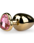 Metal Butt Plug No. 8 Gold/Pink liggandes mot vit bakgrund.