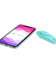 We-Vibe Moxie Trosvibrator och smartphone liggandes mot vit bakgrund.