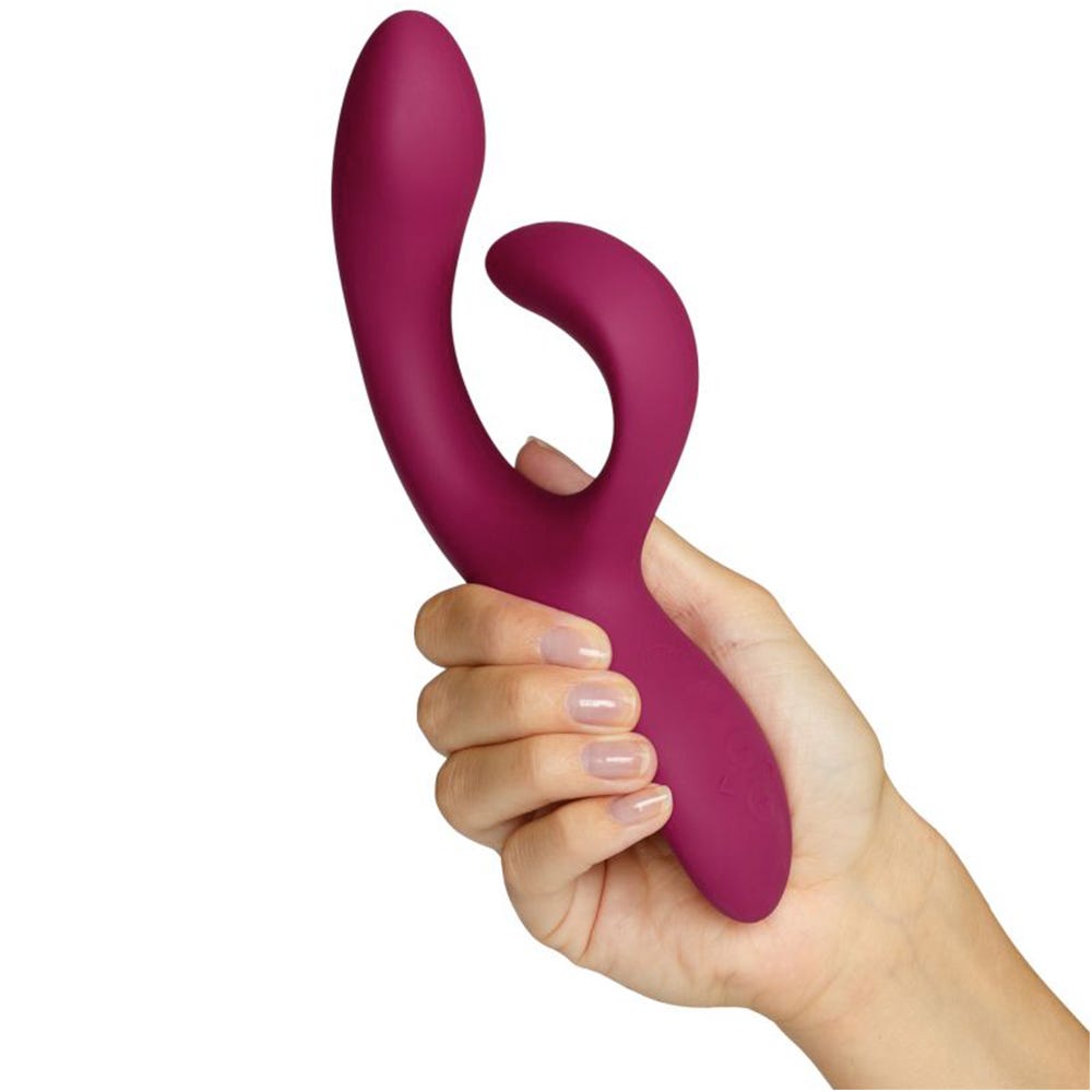 Kvinnlig hand håller i We-vibe Nova 2 Rabbitvibrator mot vit bakgrund