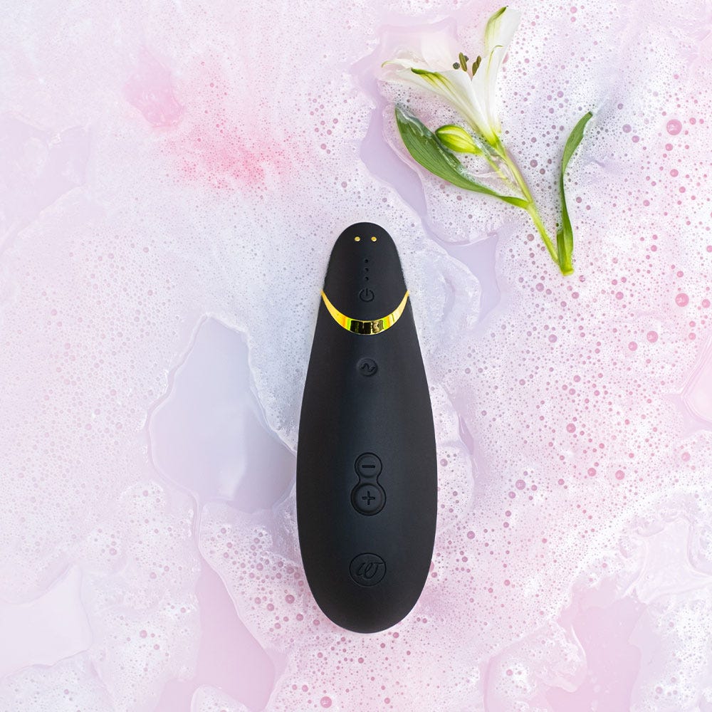 vattentät lufttrycksvibrator Womanizer Premium 2 Black. Skum i vattnet med blomma