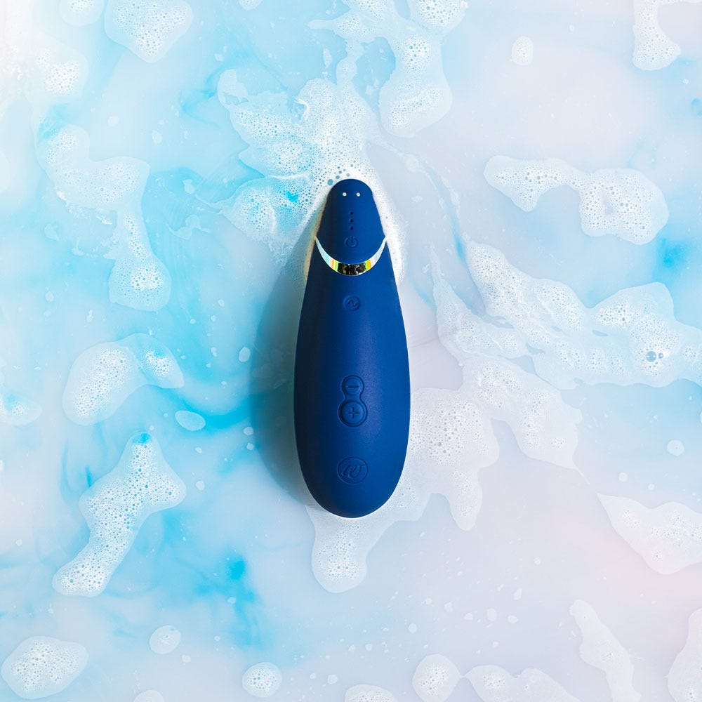 Vattentät lufttrycksvibrator Womanizer Premium 2 Blueberry i vatten med blå bakgrund och skum