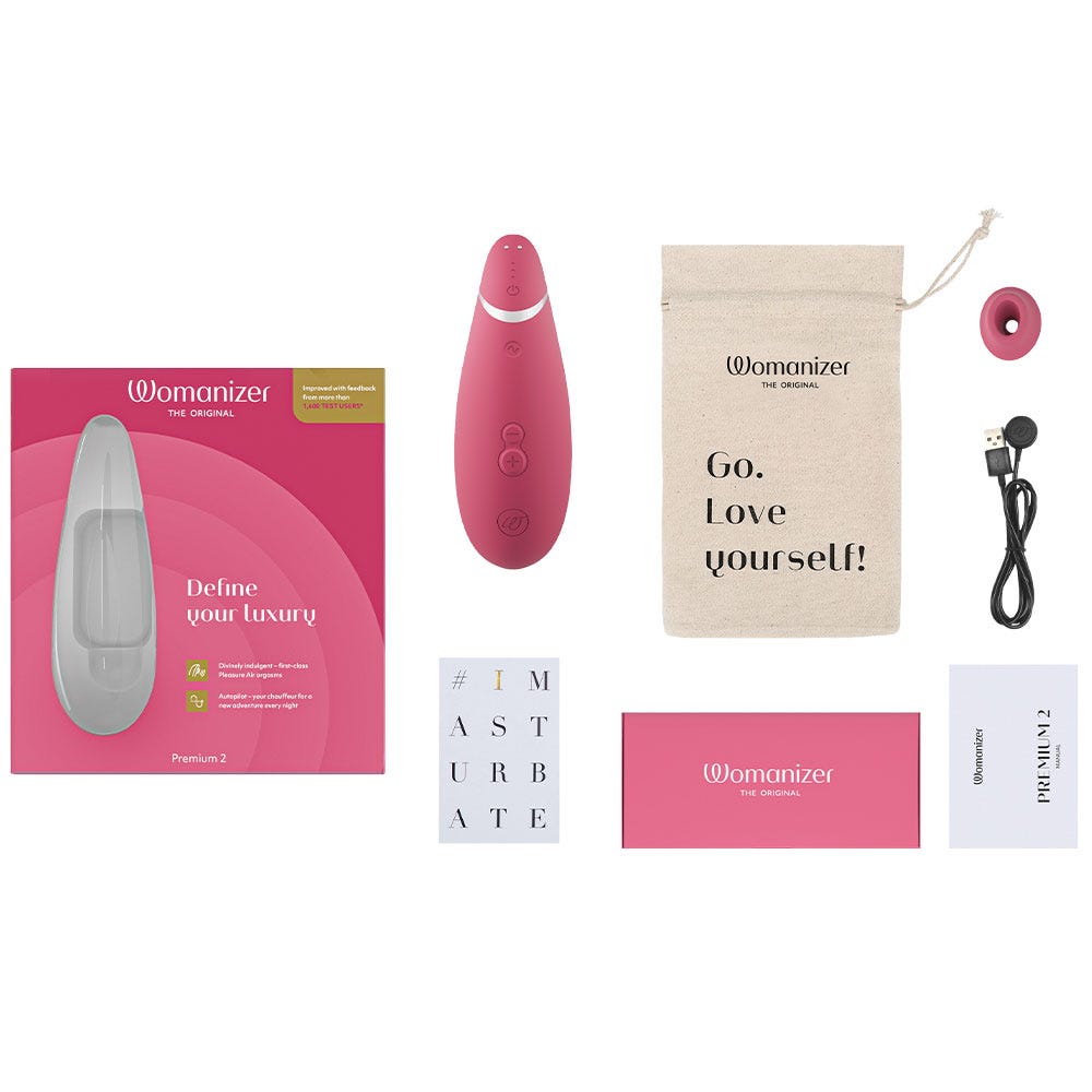 Womanizer Premium 2 Raspberry lufttrycksvibrator med tillbehör. Laddare, munsstycke och en påse som det står &quot;Go. Love Yourself!&quot;