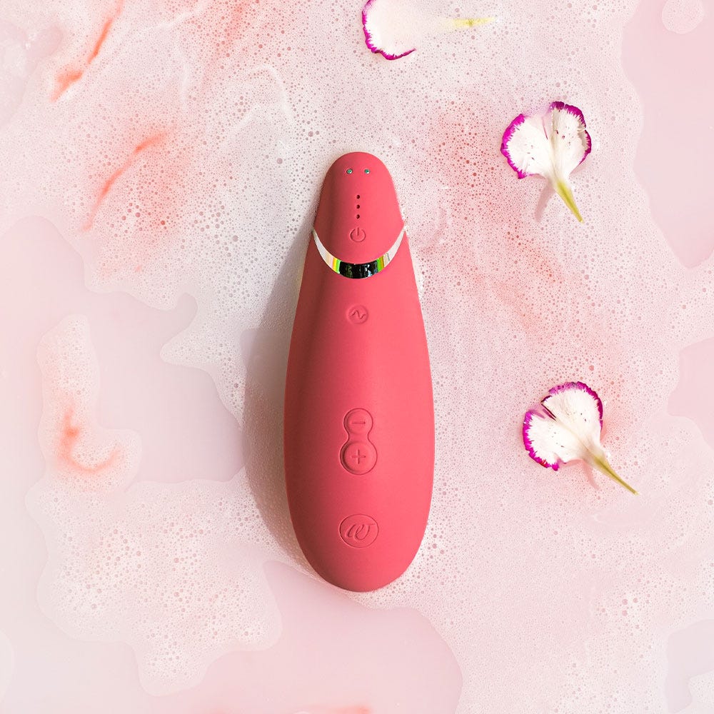 Vattentät lufttrycksvibrator Womanizer Premium 2 Raspberry. Vatten med skum och blommor. 