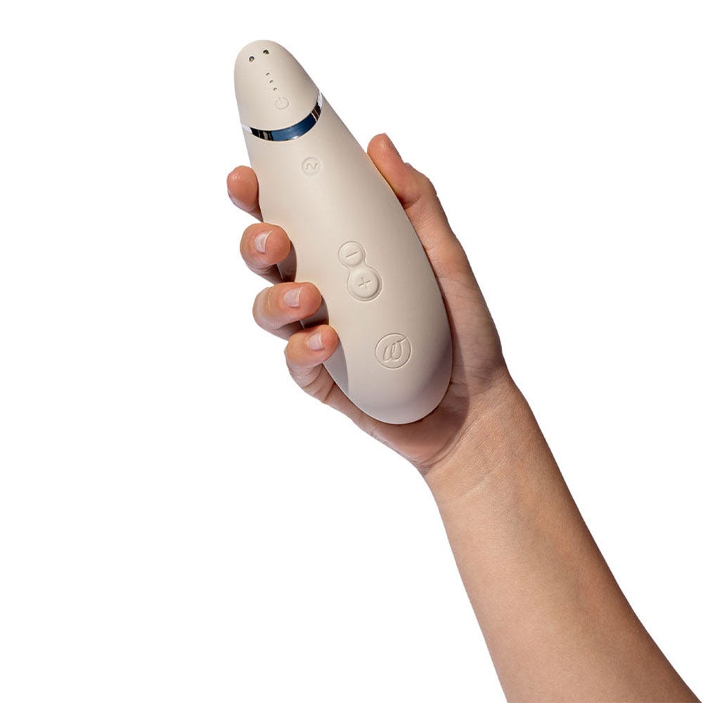 Womanizer Premium 2 Warm Gray storleksdemonstration med lufttrycksvibrator i handen