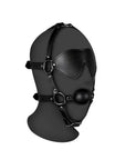 Blindfolded Head Harness with Solid Ball Gag på svart plasthuvud mot vit bakgrund.