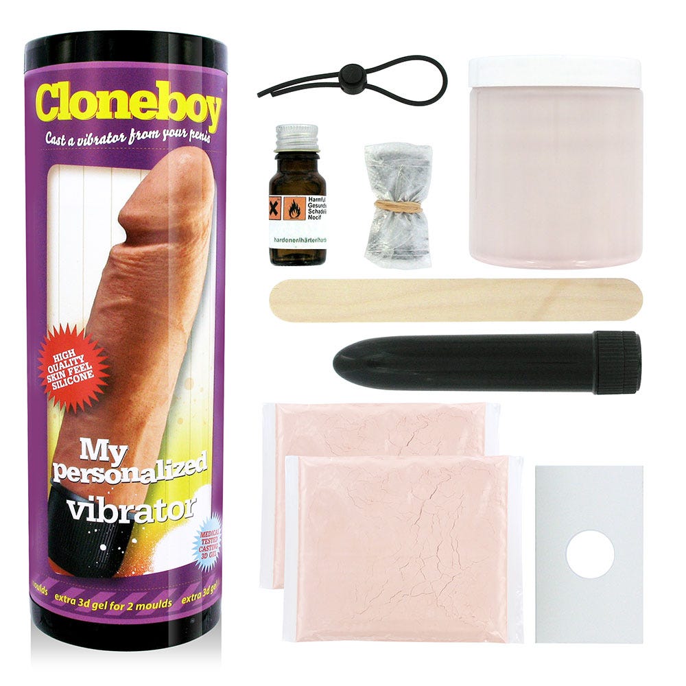 Hela kittet av Cloneboy Vibrator Nude och förpackningen till produkten. Mot vit bakgrund.