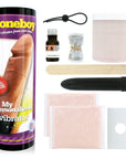 Hela kittet av Cloneboy Vibrator Nude och förpackningen till produkten. Mot vit bakgrund.