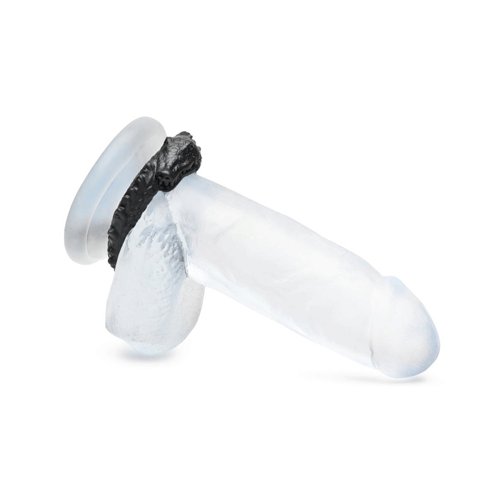 Creature Cocks Black Caiman Silicone Penisring på en genomskinlig dildo mot vit bakgrund.