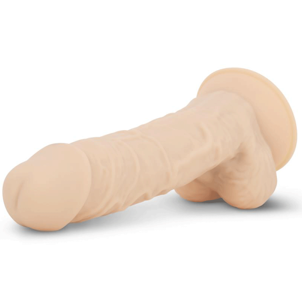 Deluxe Percy Realistisk Dildo liggandes mot vit bakgrund.