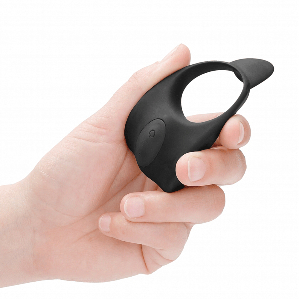 Hand som håller i E-Stimulation Cockring &amp; C-Spot Massager mot vit bakgrund.