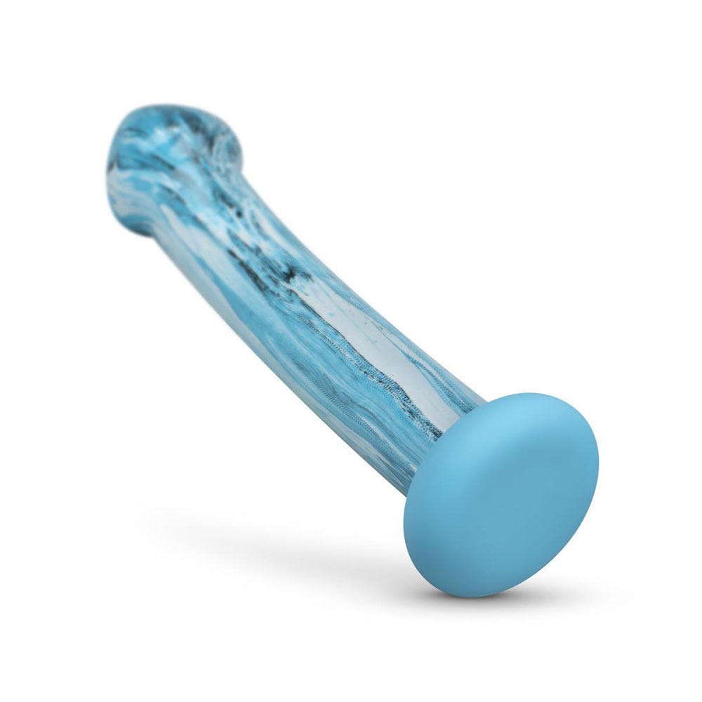 Gildo Ocean Ripple Glass Dildo lutandes mot vit bakgrund.