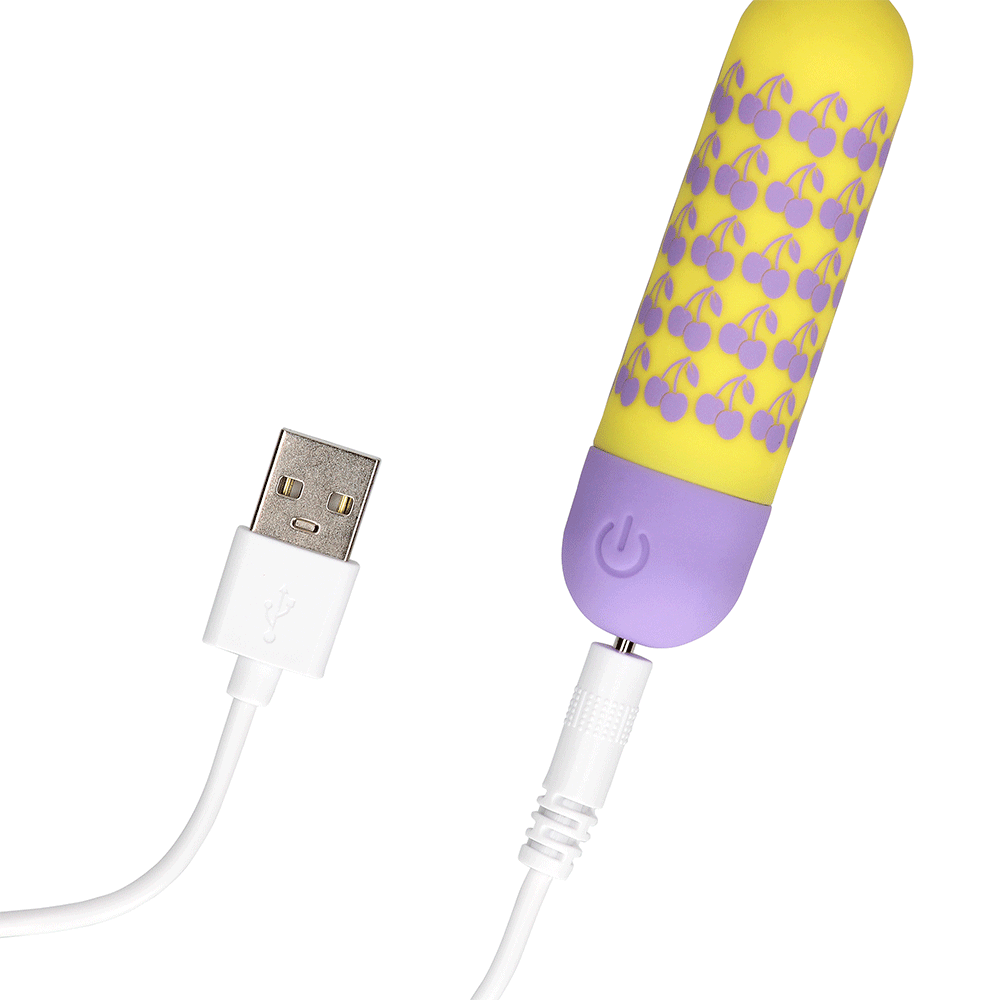 I Cherryish You Bulletvibrator med i kopplad USB-laddare mot vit bakgrund.