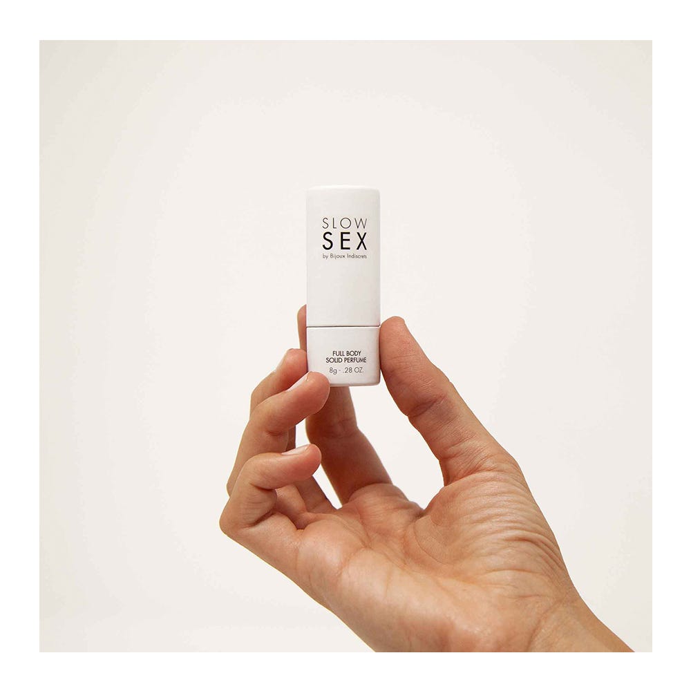 Hand som håller i Full Body Solid Perfume - Slow Sex mot vit bakgrund.