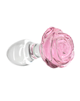 Pillow Talk Rosy Luxurious Glass Anal Plug with Bonus Bullet liggandes mot vit bakgrund.