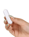 Hand som håller i Pillow Talk Rosy Luxurious Glass Anal Plug with Bonus Bullet bulletvibrator mot vit bakgrund.