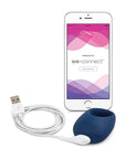 We-Vibe Pivot Vibrerande Penisring, smartphone och USB-laddare mot vit bakgrund.