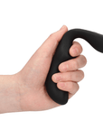 En hand med ljus hud som håller en Pointed Vibrating Prostate Massager with Remote Control mot vit bakgrund.