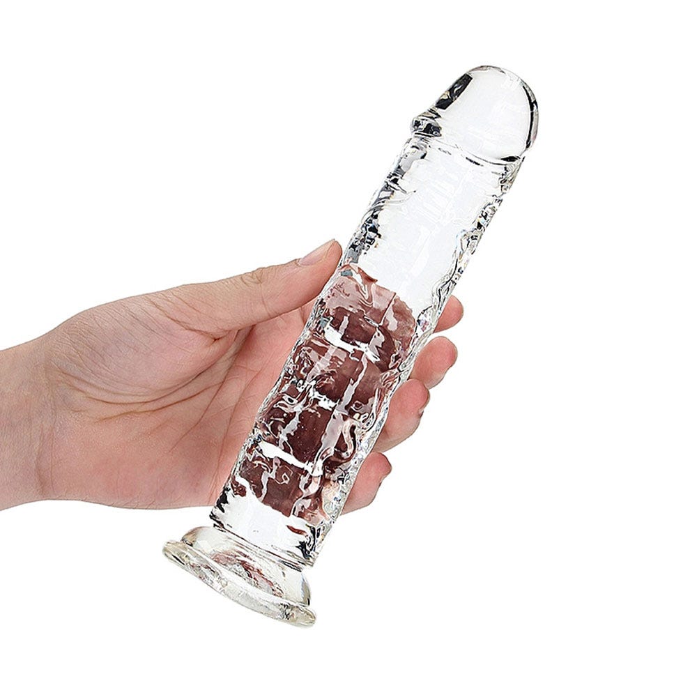 Hand som håller i RealRock Dildo with Suction Cup Clear 20cm mot vit bakgrund.