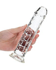 Hand som håller i RealRock Dildo with Suction Cup Clear 20cm mot vit bakgrund.