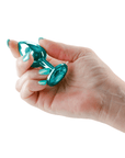 Hand som håller i Rear Assets Buttplug Small Teal mot vit bakgrund.