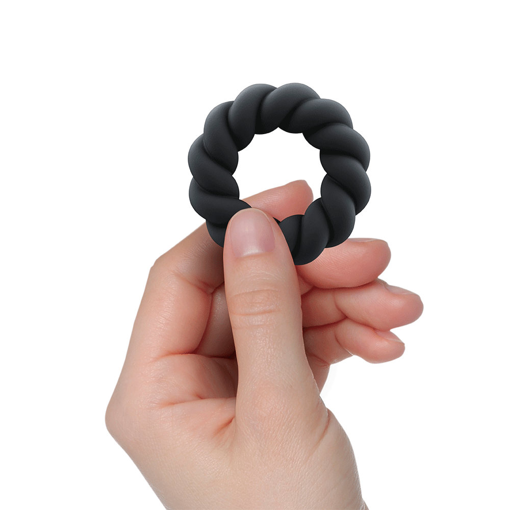 Hand som håller i Rocks-off Twist Liquid Silicone Ring mot vit bakgrund. Shoppa penisring och sexleksaker för män på Lustly.se