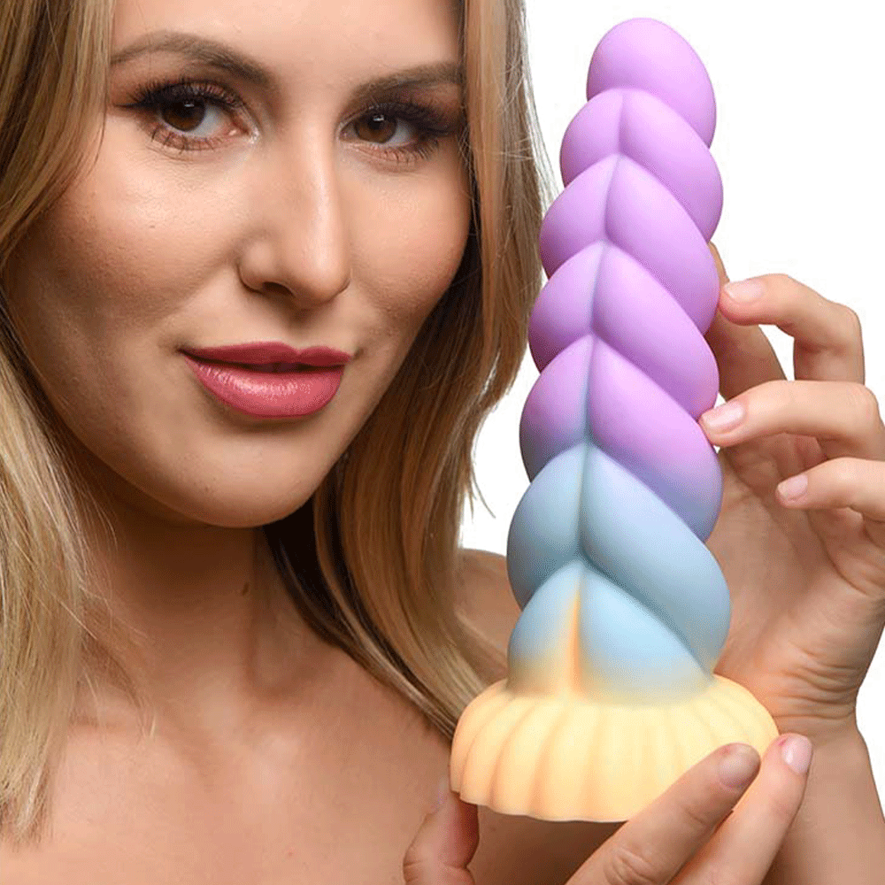 Kvinna som håller i Silicone Unicorn Dildo mot vit bakgrund.