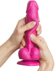 Händer som håller i Strap-On-Me Sliding Skin Realistic Dildo Fuchsia S mot vit bakgrund.