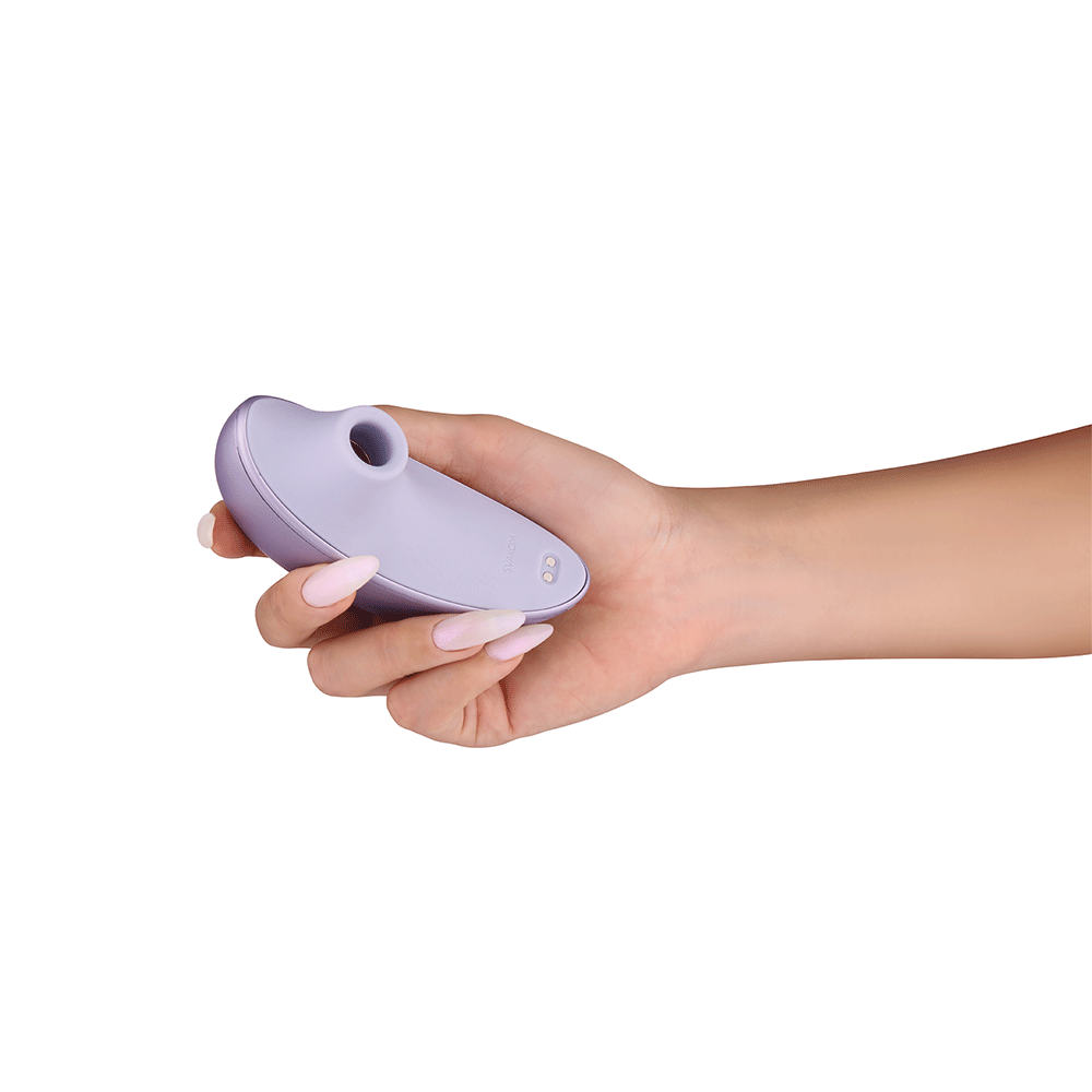 Hand som håller i Svakom Pulse Galaxie Lilac  Lufttrycksvibrator klitorisvibrator mot vit bakgrund.