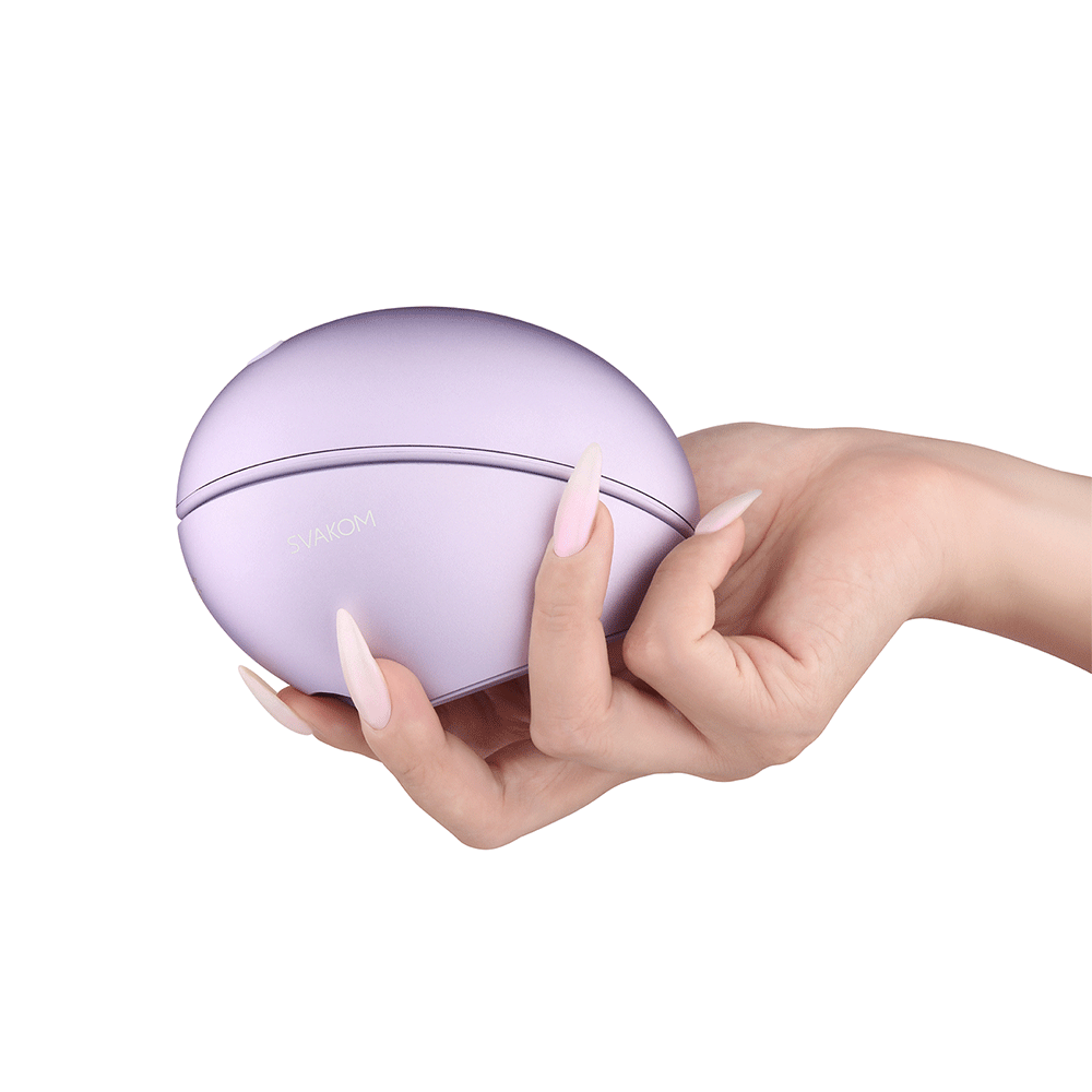 Hand som håller i stängd Svakom Pulse Galaxie Lilac Lufttrycksvibrator mot vit bakgrund.