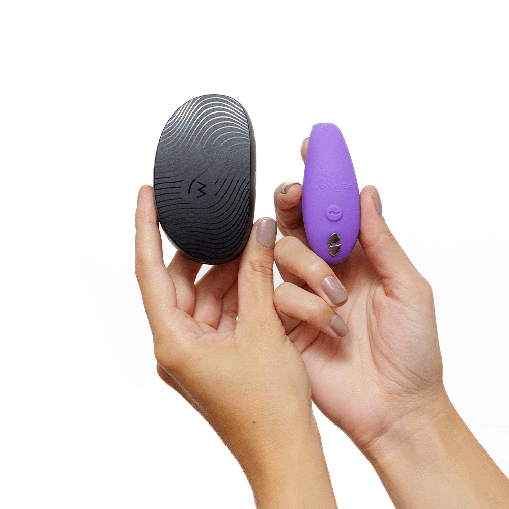 Händer som håller Sync Go Light Purple vibrator och resefodral mot vit bakgrund.