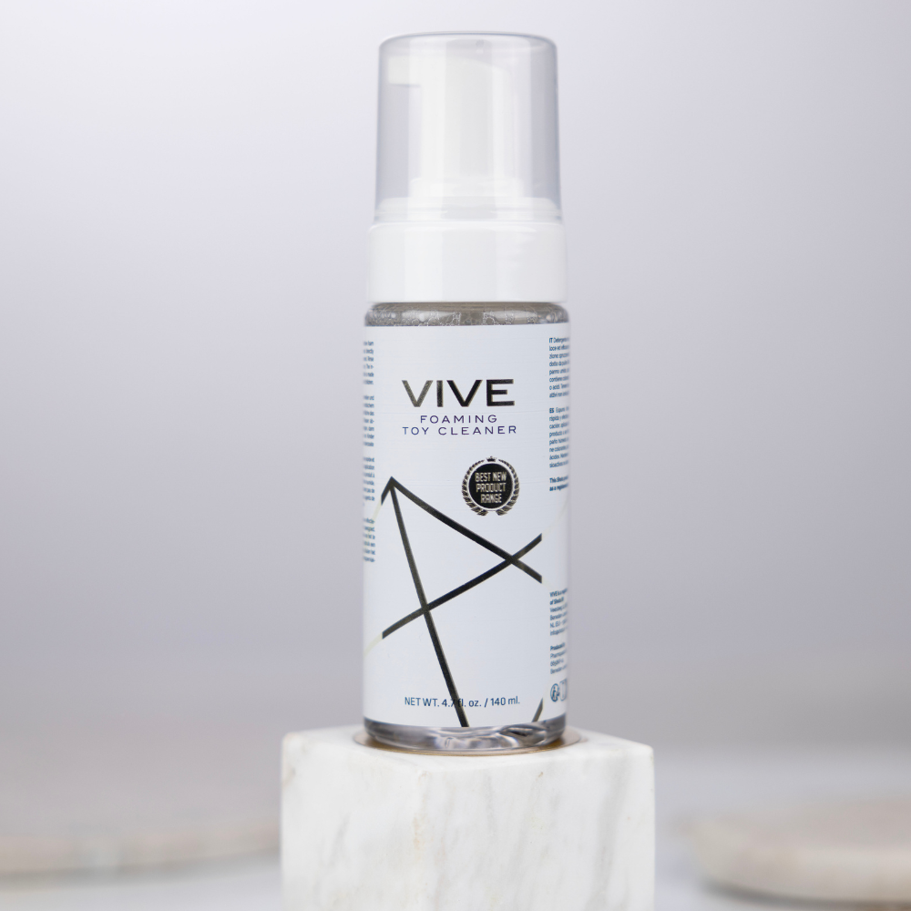 Vive Foaming Toy Cleaner 140ml i ett grått rum med grå väggar.