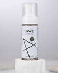 Vive Foaming Toy Cleaner 140ml i ett grått rum med grå väggar.