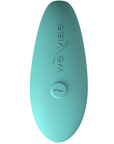 We-vibe Lite Aqua ovanifrån. En knapp med logotyp. Vit bakgrund.