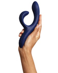 Hand som håller i We-Vibe Nova 2 Rabbitvibrator Midnight Blue mot vit bakgrund.